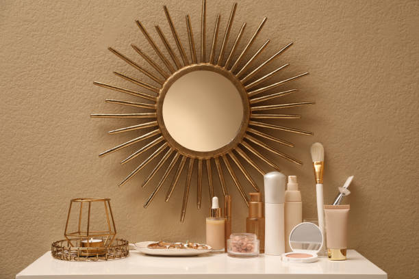 istock Stylish round mirror on wall over dressing table with makeup products 1427974393