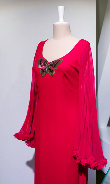 istock Female tailors mannequin with an old-fashioned red gown with a sequin butterfly. 1427975111