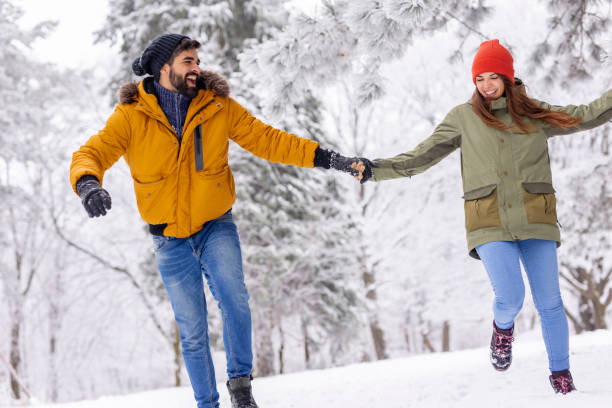 istock Couple having fun running in the snow while on winter vacation 1427976363