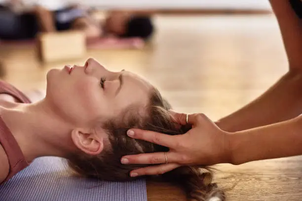 Woman, yoga and meditation with coach in class while lying on the floor breathing, spiritual and wellness. Breathe, faith and relax with a pilates teacher in a health workshop or studio with balance