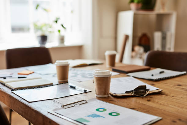 Empty meeting room table, coffee and clipboard, paper or documents or charts. Modern interior of home office, workplace and preparation for business with stationary and planning for company work.