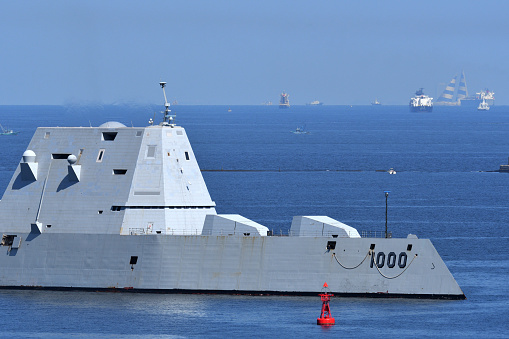 Navy frigate enters a harbour after offshore training exercises.