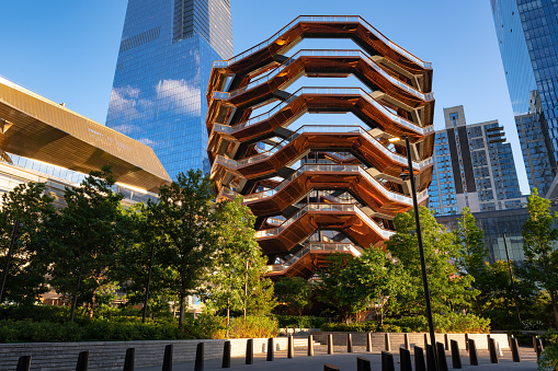 New York City, NY, USA - June 19, 2022:  The Vessel (sculptural staircase) on Hudson Yards esplanade at sunset in summer. Midtown West, Manhattan