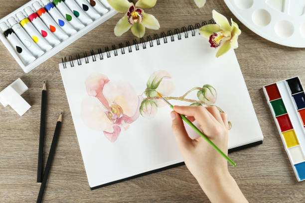 istock Woman drawing beautiful orchid 1427990912