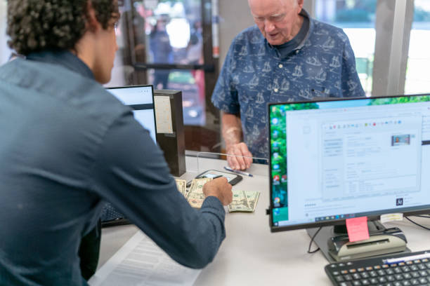 istock Bank teller counting money for customer 1427993579