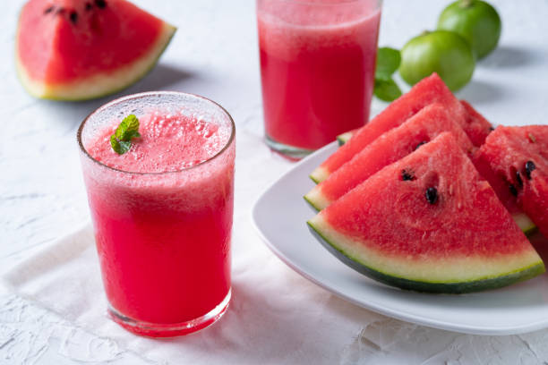 Watermelon smoothie topping with fresh mint leaves Watermelon smoothie topping with fresh mint leaves on wood background watermelon juice stock pictures, royalty-free photos & images