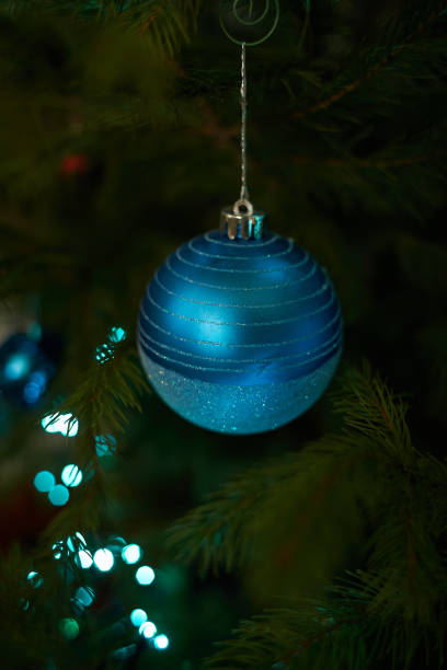 Close up of holiday electric blue garlands on fir branch with Christmas tree decoration and candy sweet. Candy cane hanging onto the branch of a Christmas tree Close up of holiday electric blue garlands on fir branch with Christmas tree decoration and candy sweet. Candy cane hanging onto the branch of a Christmas tree candy cane flash stock pictures, royalty-free photos & images