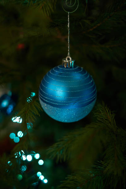 крупным планом праздничные электрические синие гирлянды на еловой ветке с елочным украшением и конфетно-сладкими. конфетная трость, висящ� - hard candy flash стоковые фото и изображения