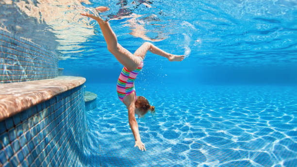 istock Happy child dive underwater with fun in swimming pool 1427999290