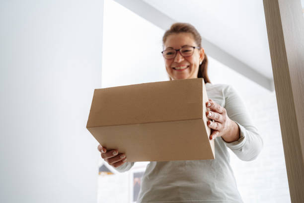 istock Happy woman getting her online order at home 1427999433