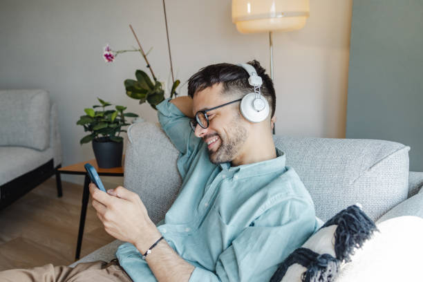 istock A smiling man listening to music and texting 1428000784