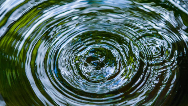 kropelki wody wpływają na powierzchnię, tworząc pierścienie na powierzchni. - ripple nature water close to zdjęcia i obrazy z banku zdjęć