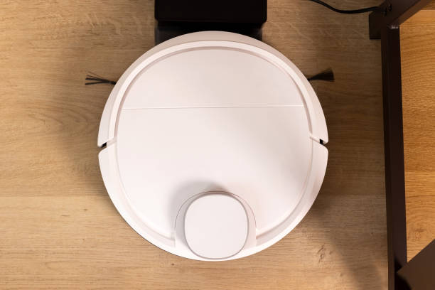 istock Modern robot vacuum cleaner on wooden floor 1428002399