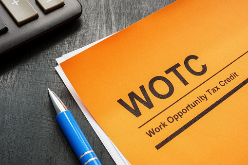 Work opportunity tax credit WOTC application, pen and a notepad.