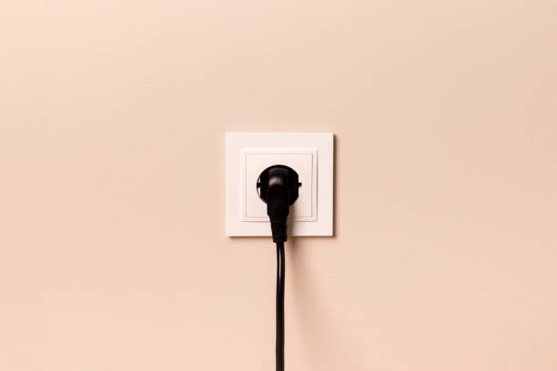 istock Electrical outlet with plug on beige wall 1428002760