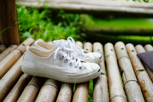 White sneakers on bamboo board