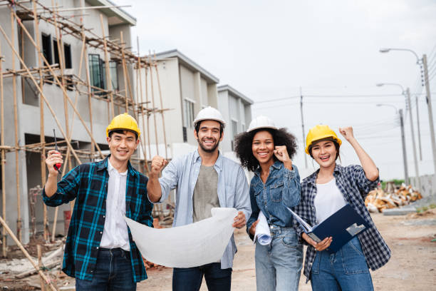 istock After completing their mission or building, a group of engineers and employees raise their hands. 1428006078