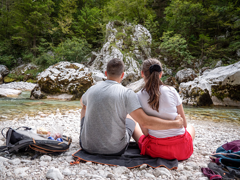 Hiking couple sitting on the river bank