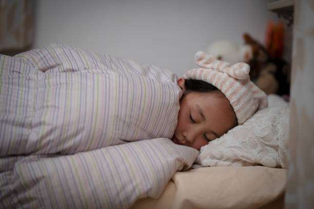 istock Girl wearing a nightcap sleeping in bed 1428013952