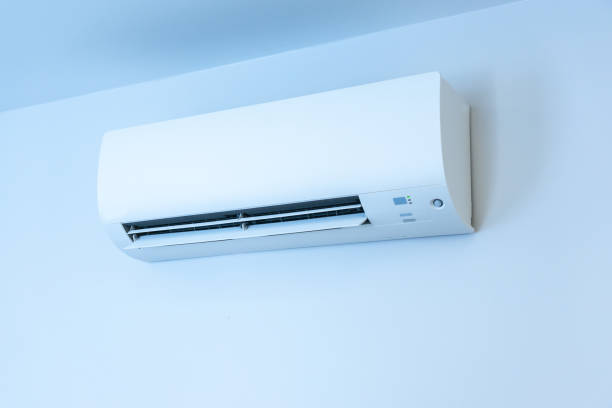 istock White wall with hanging air conditioning unit and copy space 1428015214