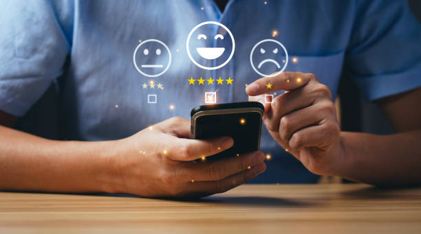 istock Customer and Consumer Satisfaction Concept. Businessmen or customers express their satisfaction through an application on a smartphone screen to choose  5 star rating and smiley face emoji 1428016837