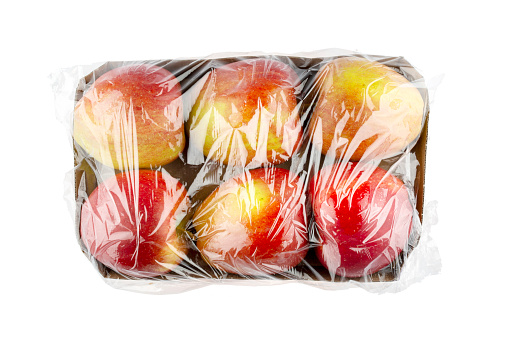 Apples in plastic wrap - concept of plastic overuse and pollution