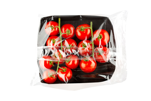 Tomatoes vegetable in plastic wrap - concept of plastic overuse and pollution