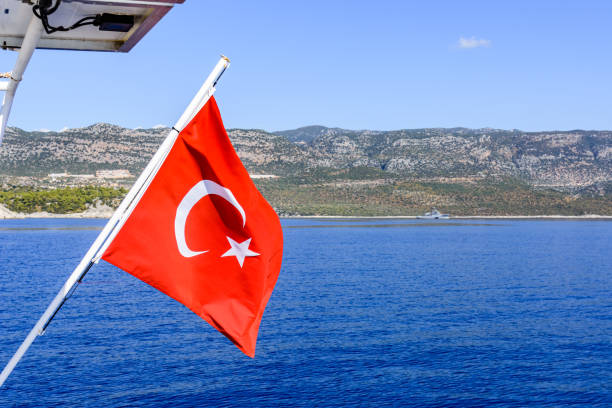 istock Red turkish flag waving over the Mediterranean sea 1428020285