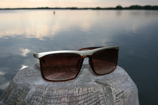 Sunglasses on the beach on a wooden platform