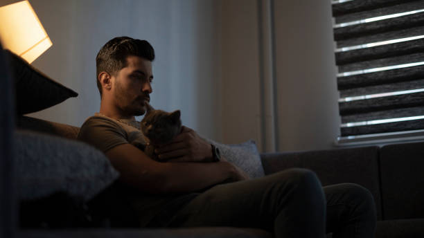 istock Thoughtful young man in low light. Dramatic concept , man sitting on sofa 1428021466