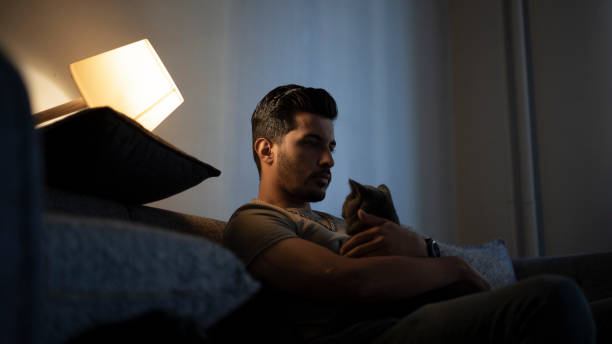 istock Thoughtful young man in low light. Dramatic concept , man sitting on sofa 1428021504