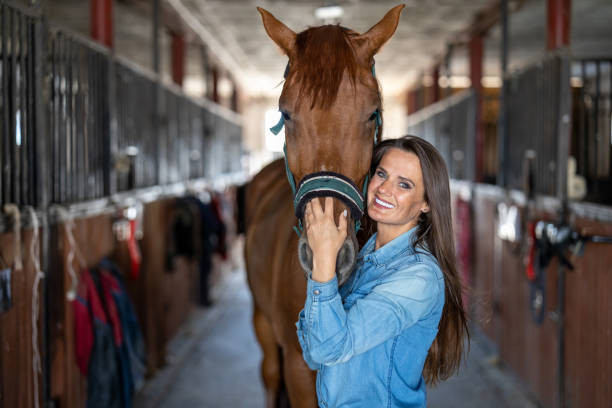 istock Young woman in a stable with her horse 1428025809