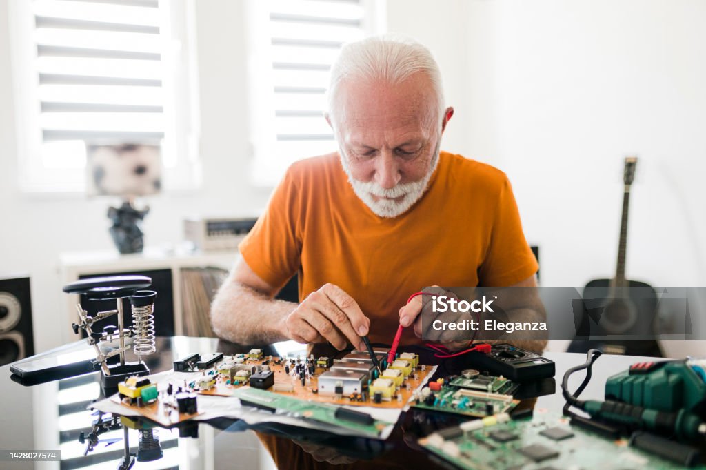 Computer repair service. Hardware support. Electronic technology. Shot of technician fixing laptop cooler. Active Seniors Stock Photo