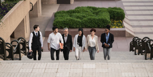 istock Colleagues talking as they walk down the steps, multiracial diverse business group, leaving work. 1428027896