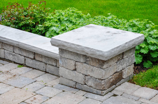 istock A tumbled paver retaining wall with natural stone coping defines a driveway. 1428029253