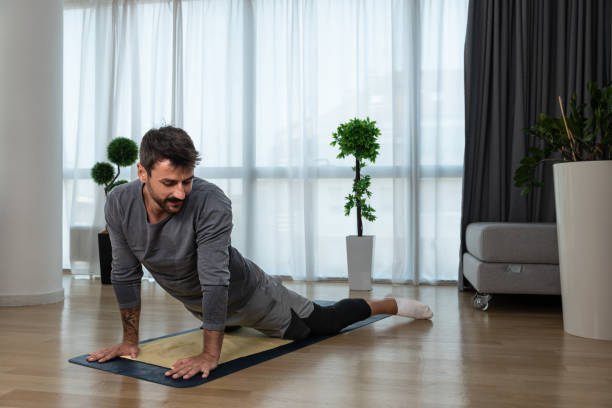 istock Young man cancer survivor practicing home workout yoga training, stretching muscles and breathing exercise for healthy life after long struggle with sickness and pain. 1428036771