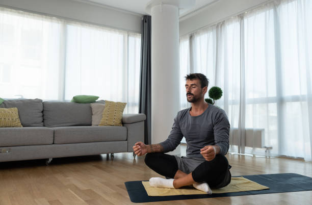 istock Young man cancer survivor practicing home workout yoga training, stretching muscles and breathing exercise for healthy life after long struggle with sickness and pain. 1428036906