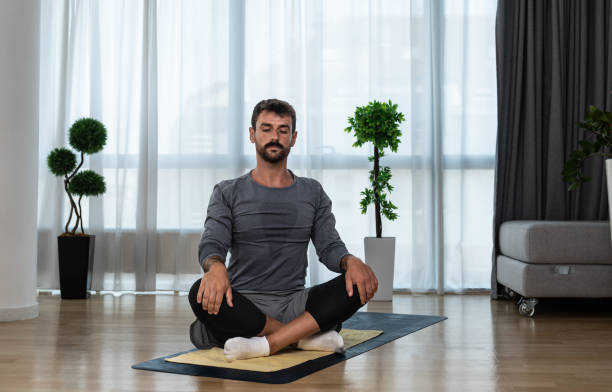 istock Young man cancer survivor practicing home workout yoga training, stretching muscles and breathing exercise for healthy life after long struggle with sickness and pain. 1428036908