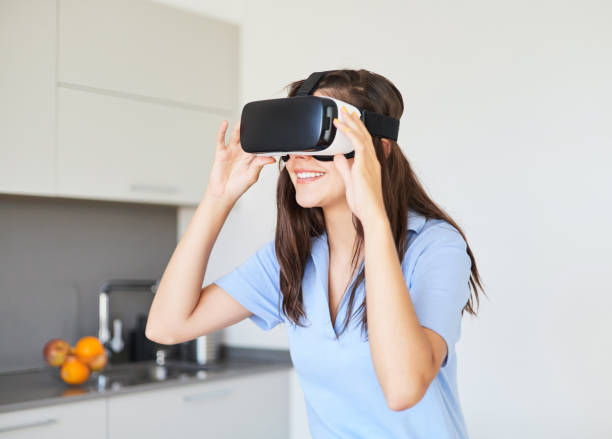 young woman wearing vr goggles simulating a digital world at home - ai finger gamer imagens e fotografias de stock