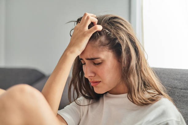 istock Sad young woman alone crying on the sofa at home 1428042996