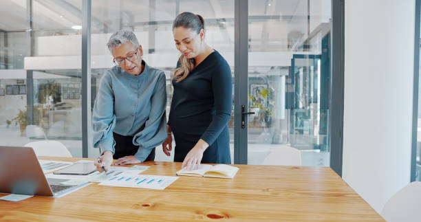 istock Teamwork, documents and finance with a female leader, manager or CEO and her employee working as a team in the office. Training, coaching and learning with a boss and intern in a development workshop 1428044059