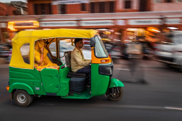 Indian man drives auto rickshaw (tuk-tuk), India Indian man drives auto rickshaw (tuk-tuk) on streets of Rajasthan, India. auto rickshaw taxi india stock pictures, royalty-free photos & images