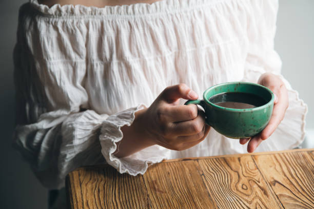 istock Close-up, green cup with coffee in female hands. 1428050248