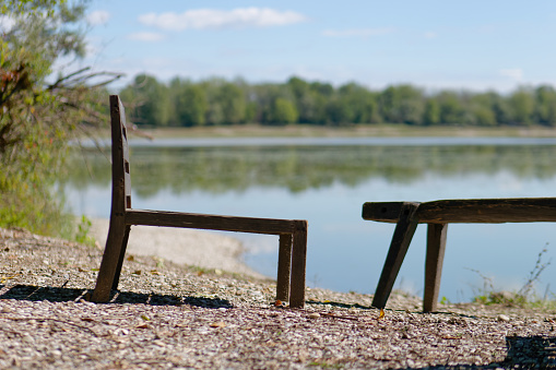 Close-up photo of a wooden chair on the lake shore