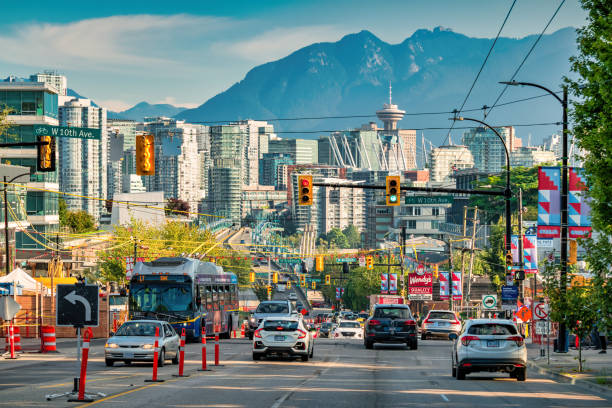 Cars and bus drive on Cambie Street in downtown Vancouver BC Canada on a sunny day.