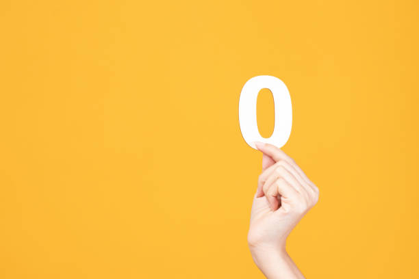 istock Hand holding wood number on yellow background. 1428069935