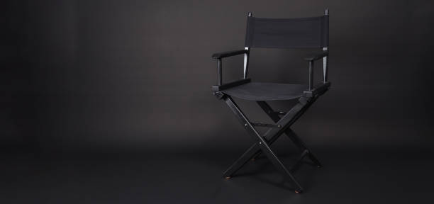 istock Black director chair isolated on black blackground. 1428071818