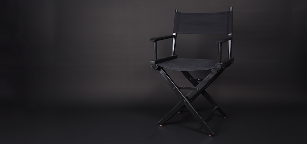Black director chair isolated on black blackground.