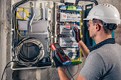 istock Man, an electrical technician working in a switchboard with fuses. 1428071835