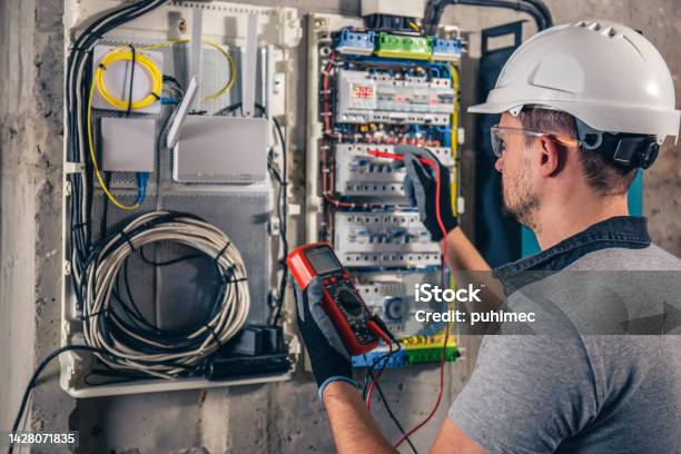 Man An Electrical Technician Working In A Switchboard With Fuses Stock Photo - Download Image Now